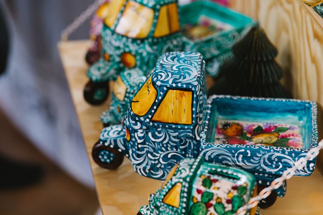 Ornate wooden cactus figurines with teal and white scrollwork patterns and yellow blooms