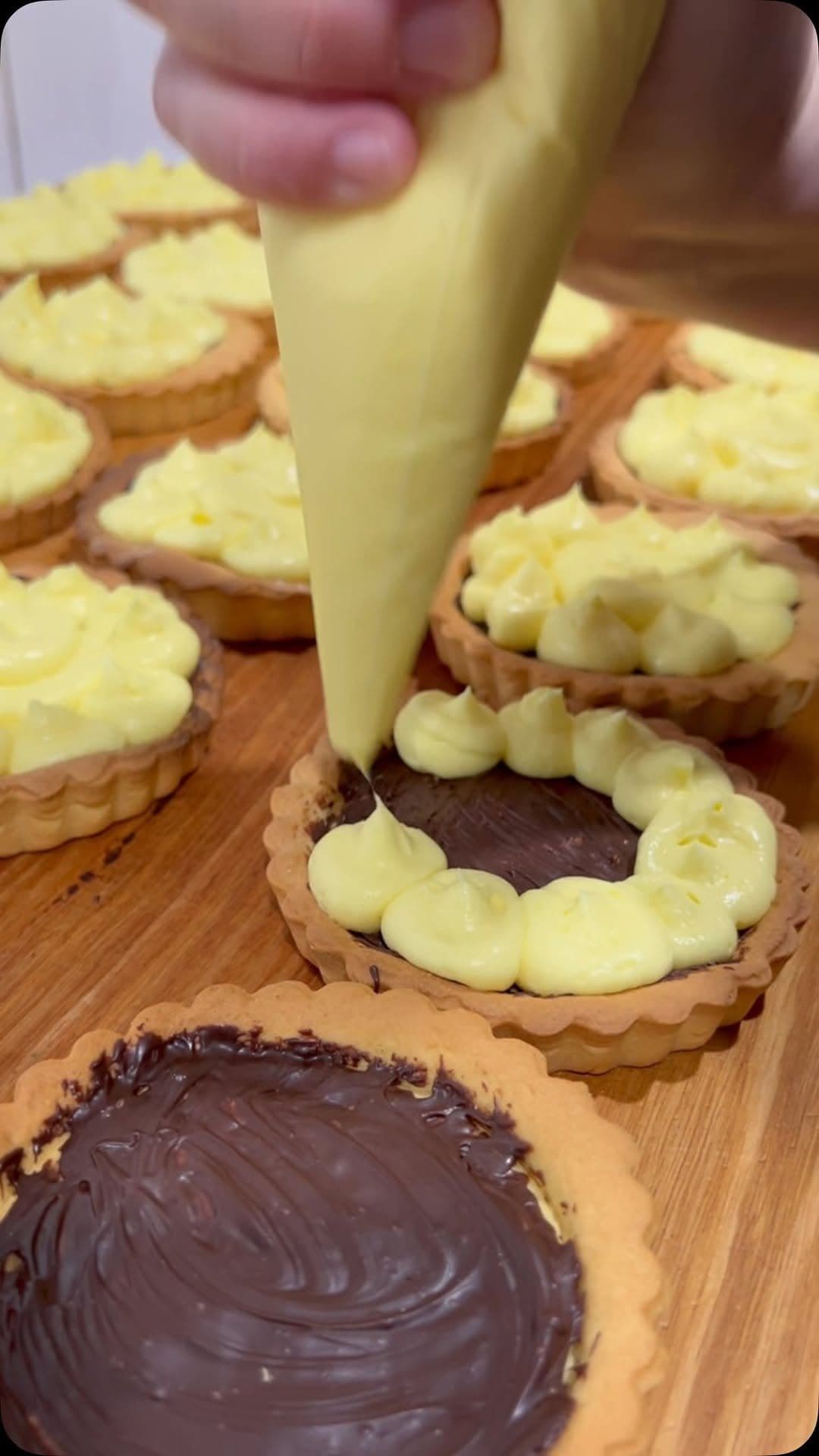 Custard being piped into pastry tarts