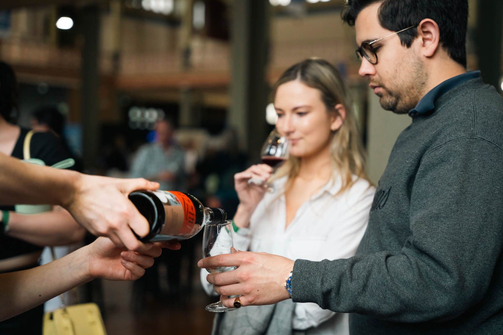 People enjoying wine in the designated wine tasting area, savouring the flavours and aromas of different selections.