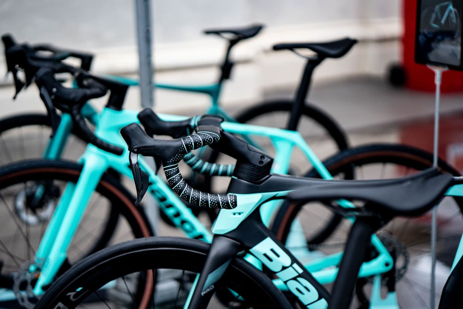 Turquoise and black racing bicycles lined up outdoors at festival