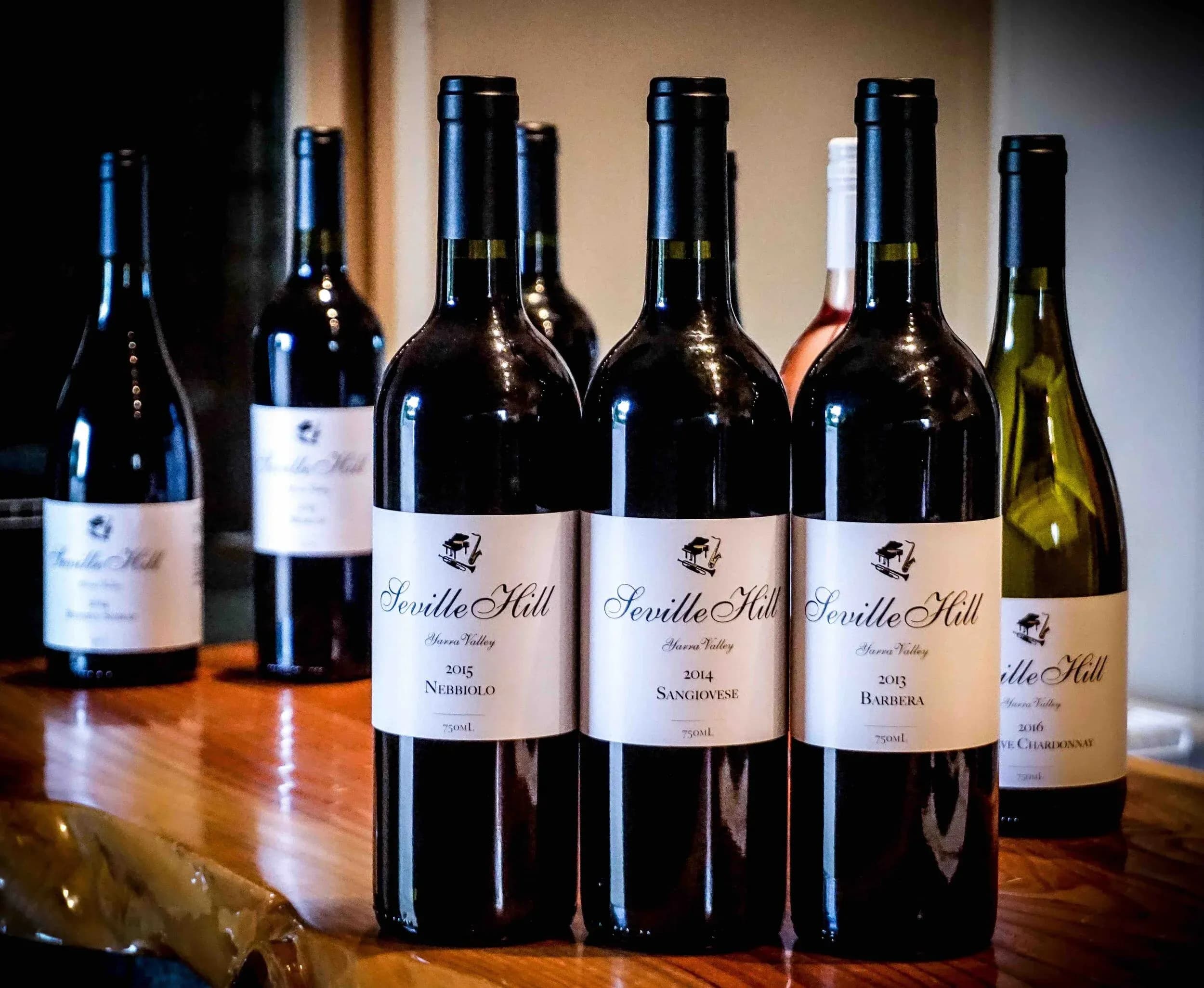 Row of Seville Hill wine bottles displayed on wooden table