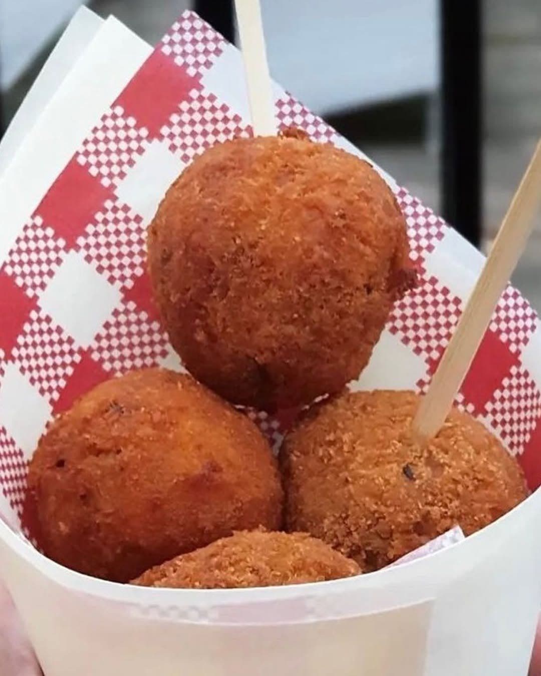 Golden arancini in a paper cone
