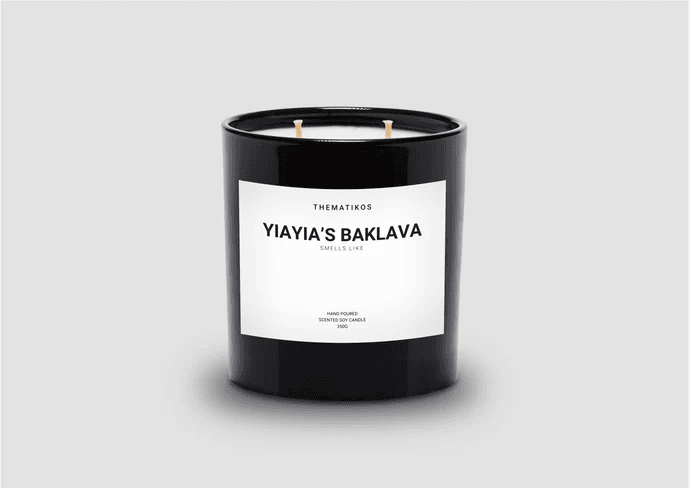 Black candle jar labeled Yiayia's Baklava scented soy candle