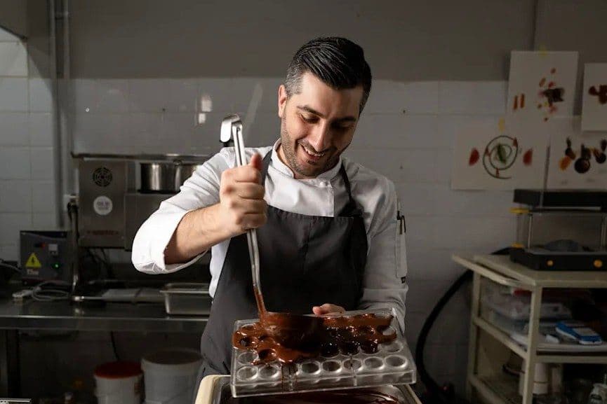 Alessandro Luppolo piping chocolate in a professional pastry kitchen