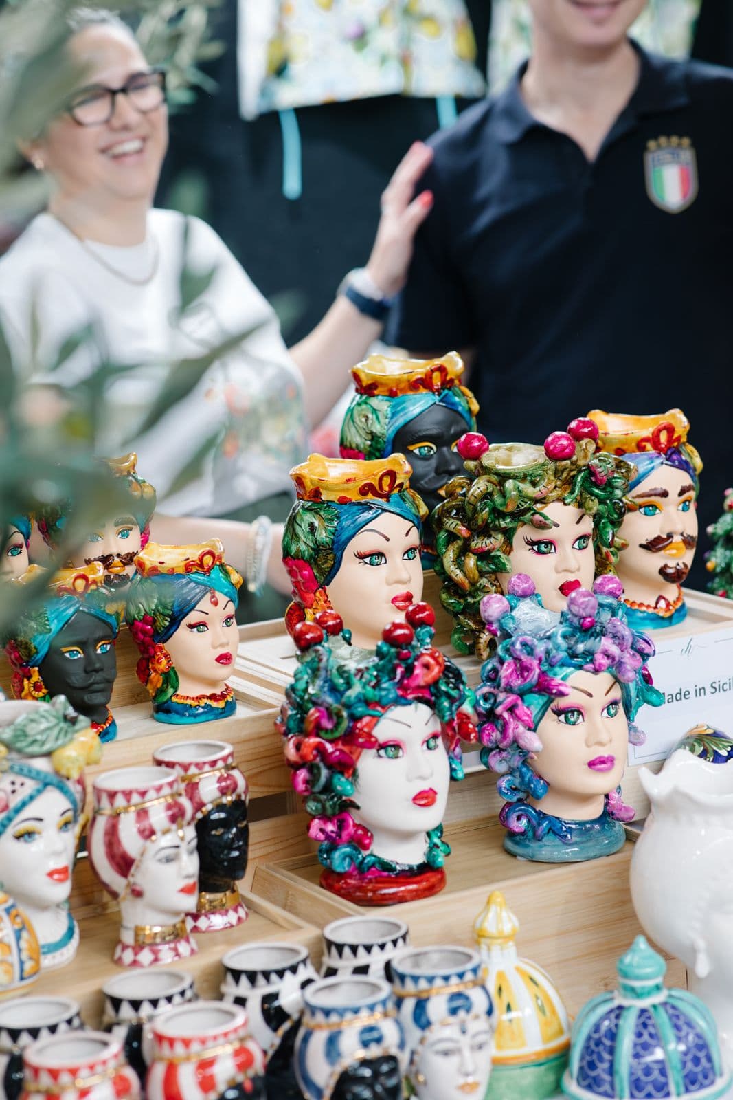 Colourful ceramic Sicilian head planters with flowers and decorative pottery displayed at Melbourne Italian Festa