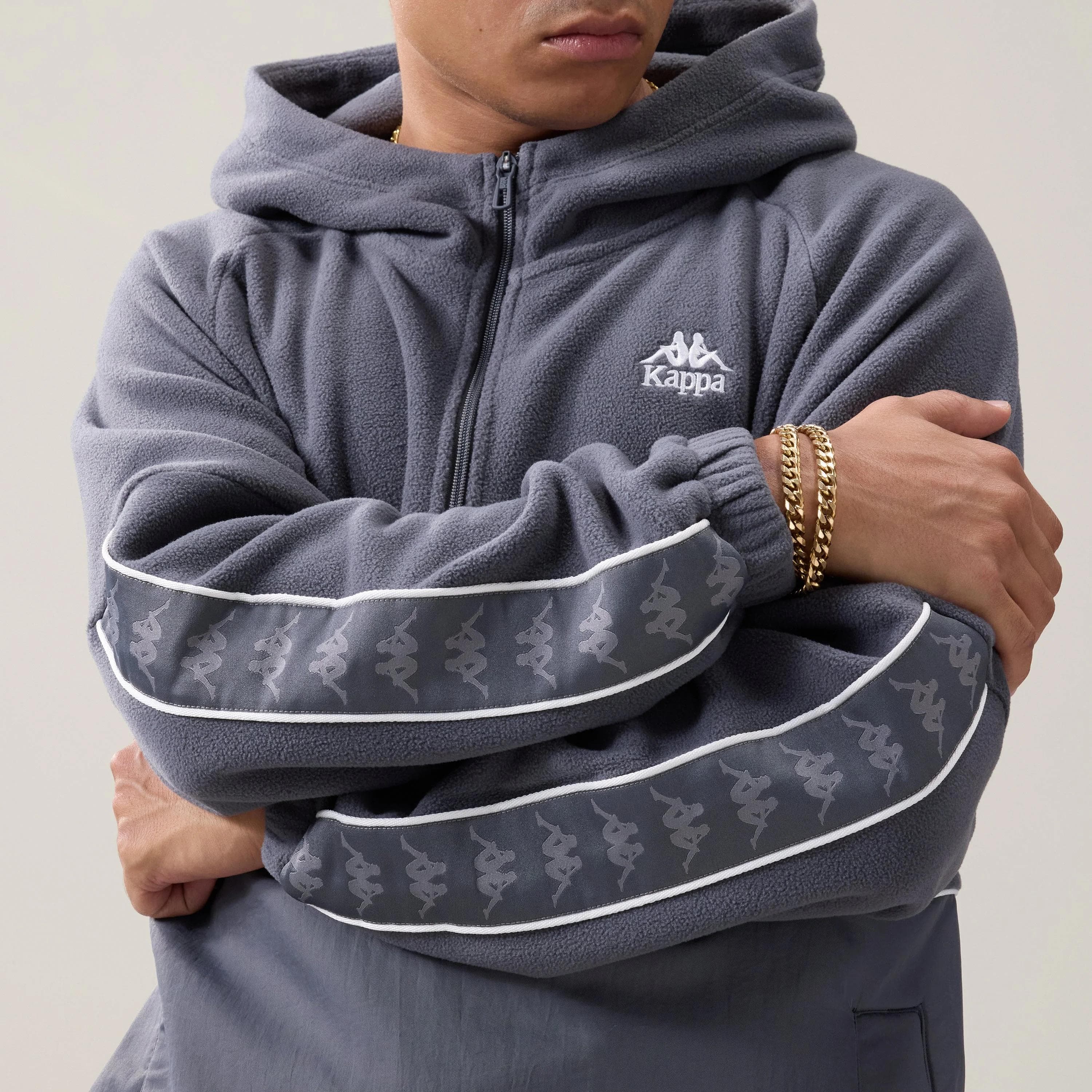 Person wearing grey Kappa fleece hoodie with logo detailing