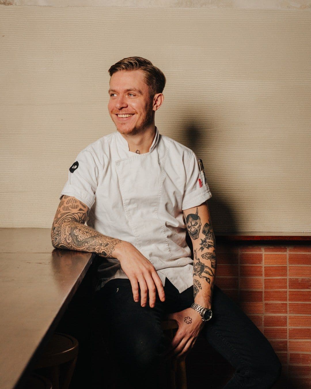 Andrea Vignali smiling, seated in a short-sleeved white chef's coat