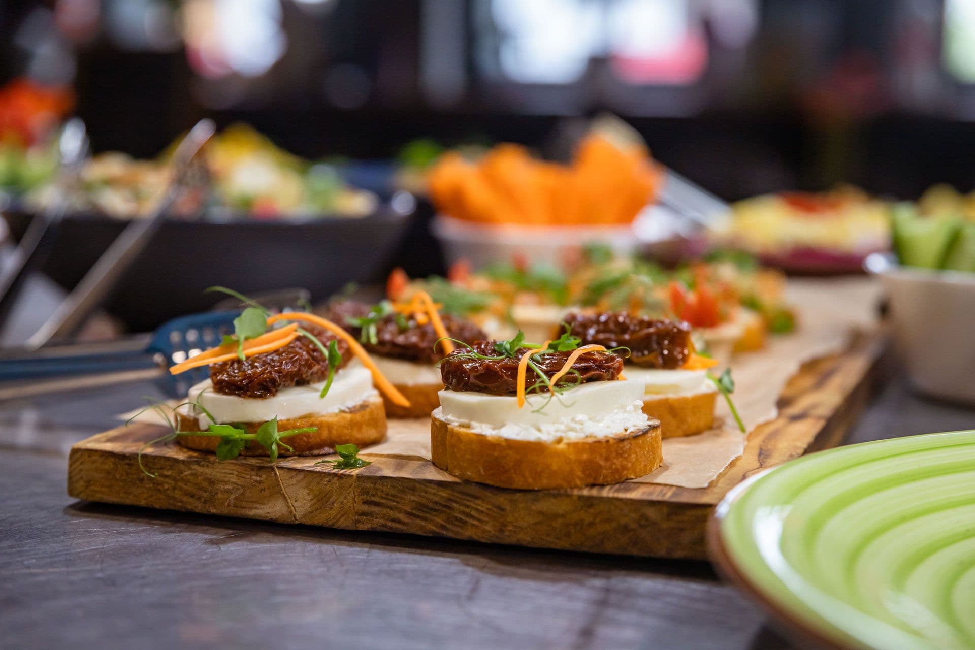 Bruschetta topped with cheese, tomato jam, and micro herbs on board