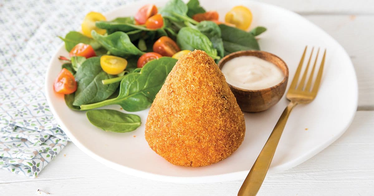Golden fried arancini cone with spinach tomato salad and dip