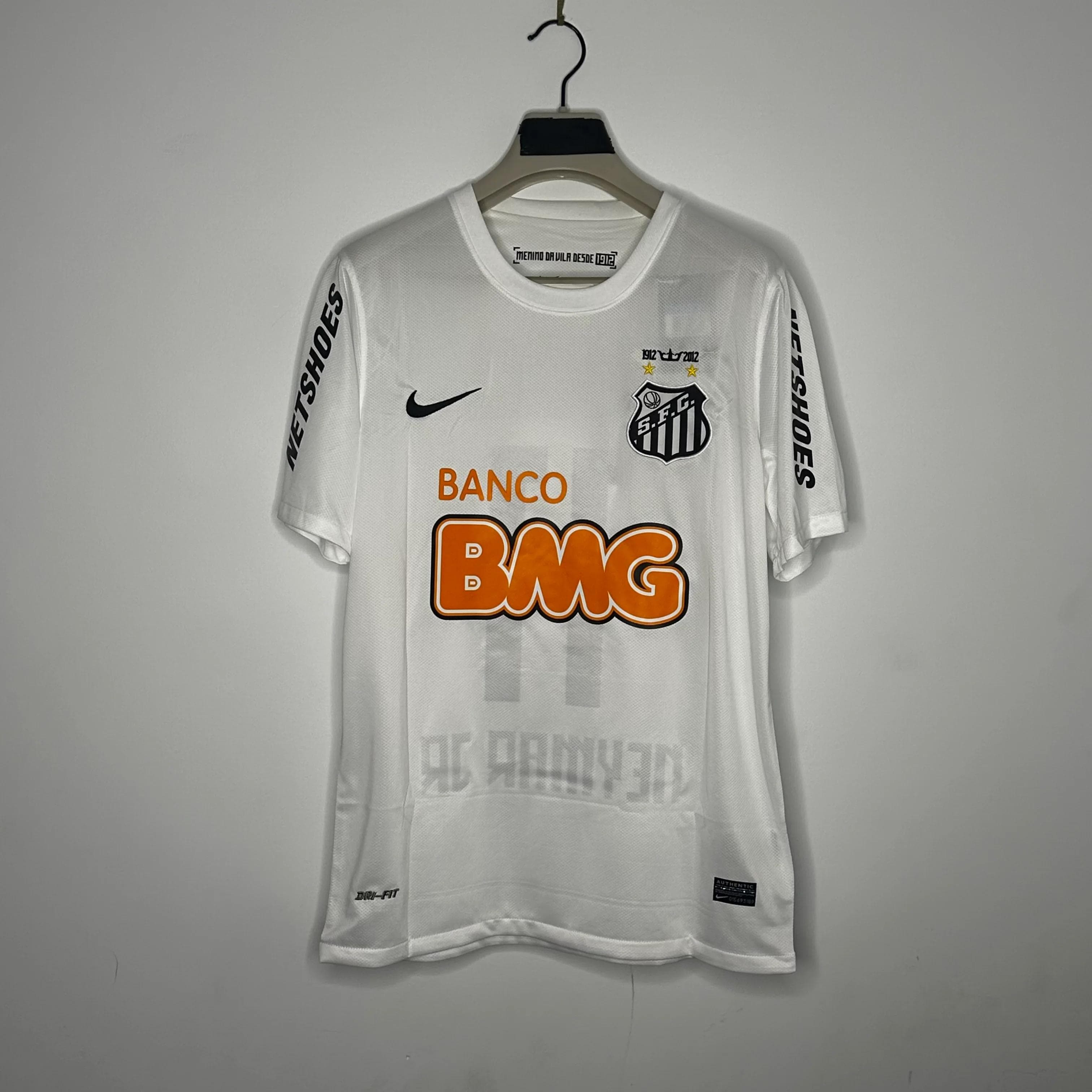 White Santos football jersey on hanger against plain wall