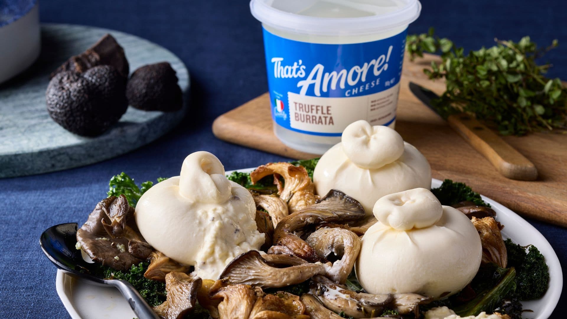 Burrata cheeses on mushrooms beside That's Amore truffle burrata tub