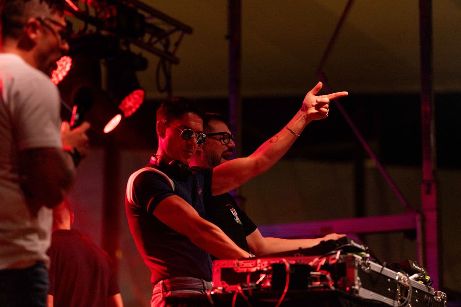 DJ and dancers on an illuminated stage at night