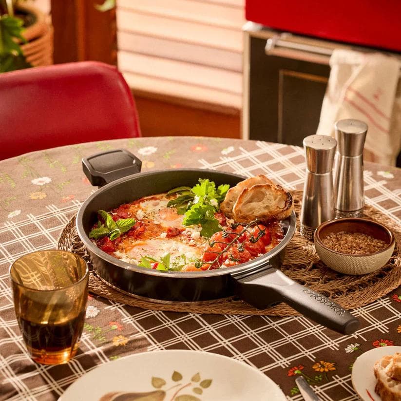 Shakshuka style eggs in dark pan on table setting